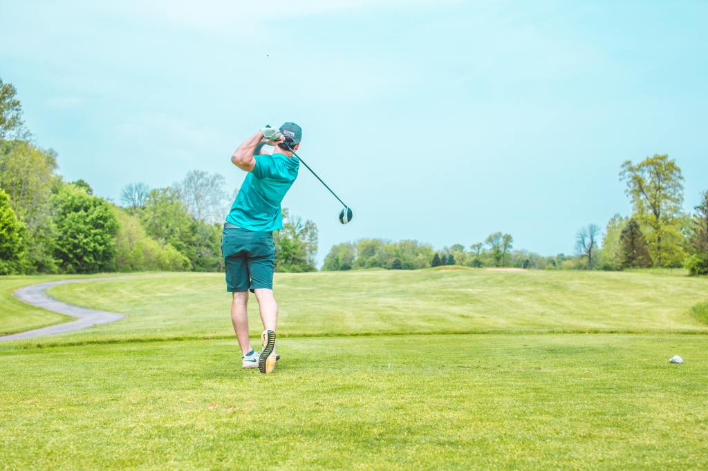Golfer swinging on golf course